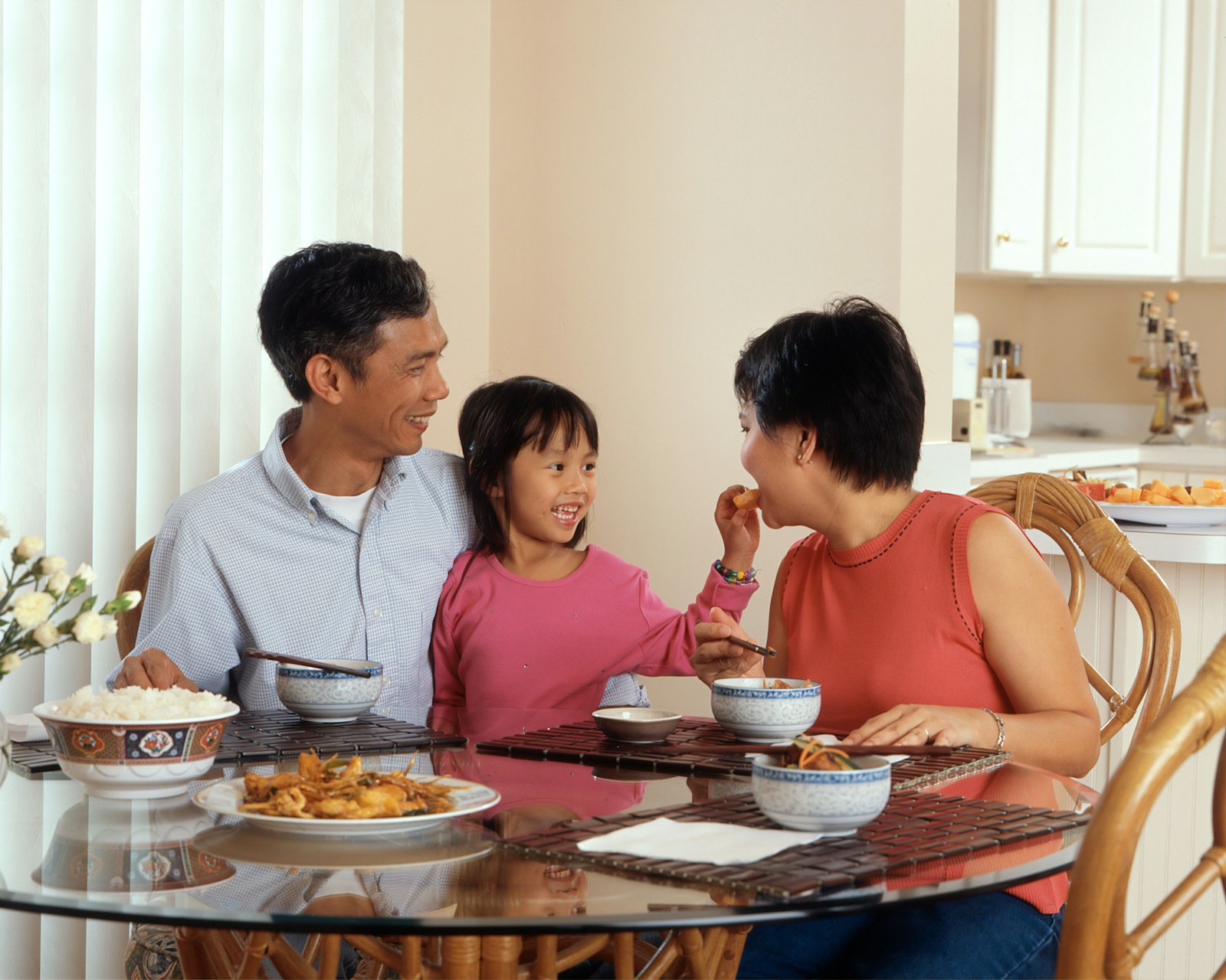Family sharing Chinese dishes and rice bowls at the dinner table